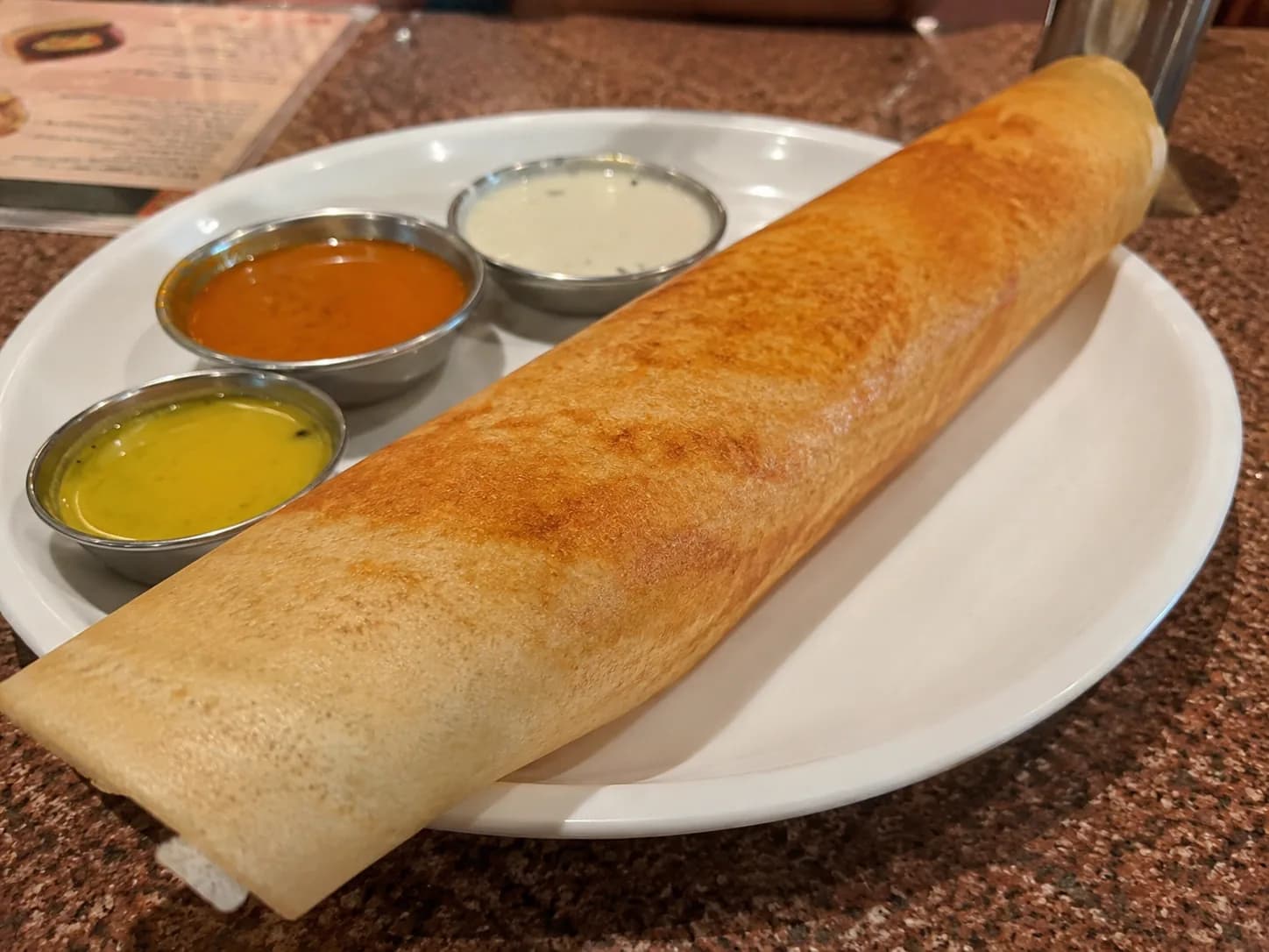 Before: a masala dosa photographed on a restaurant table under ordinary lighting